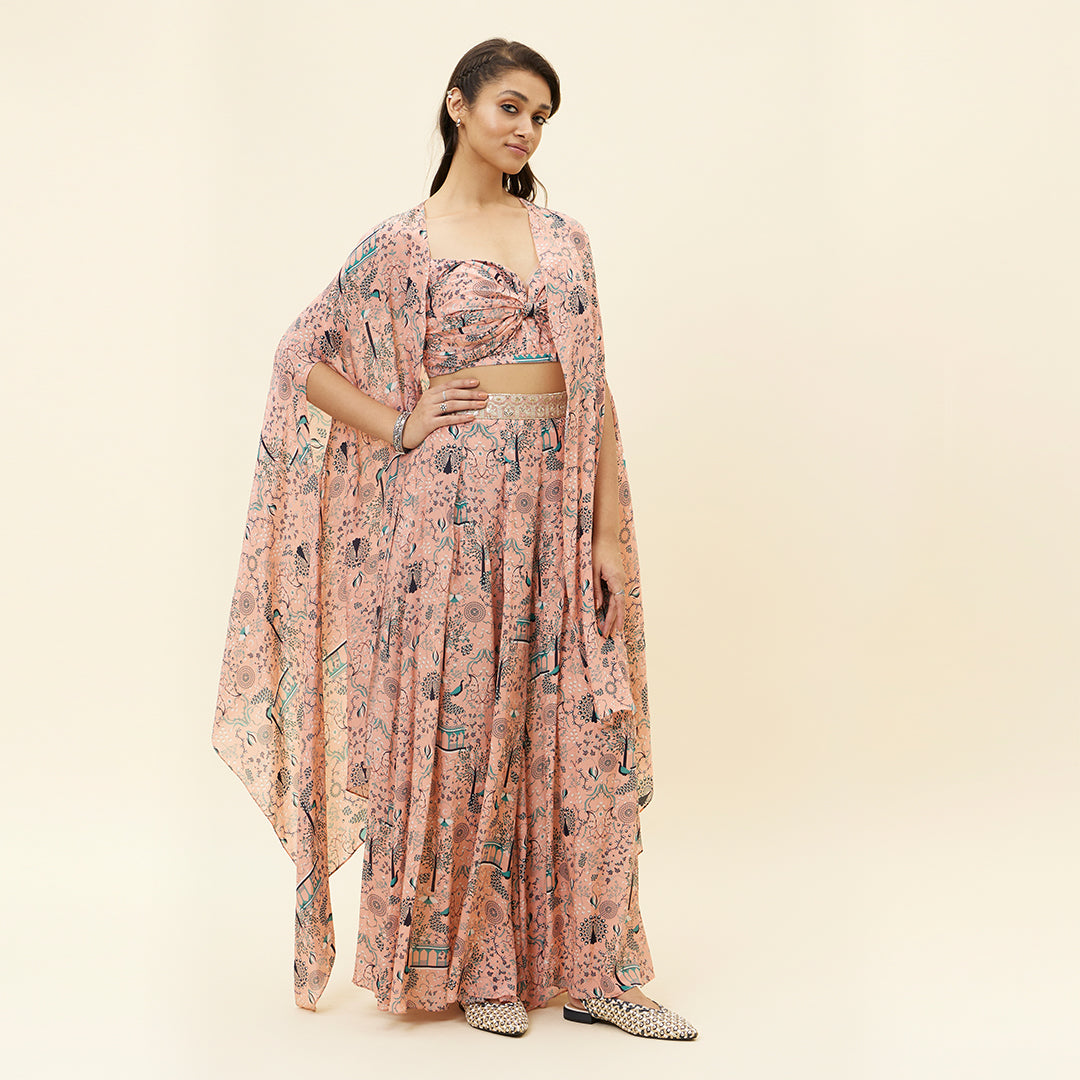 PINK MOR JAAL PRINT BIKINI BUSTIER TEAMED WITH BOX PLEATED PANTS AND A CAPE