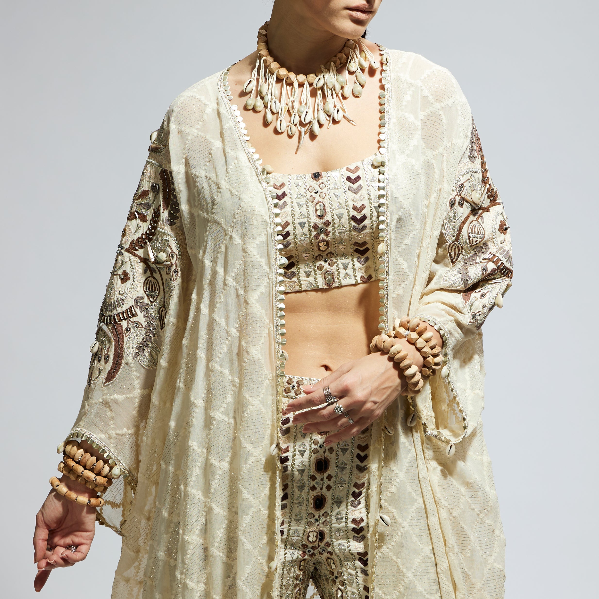 SAMSARA: IVORY AZTEC EMBELLISHED CAPE PAIRED WITH HEAVILY EMBELLISHED BUSTIER AND PANTS