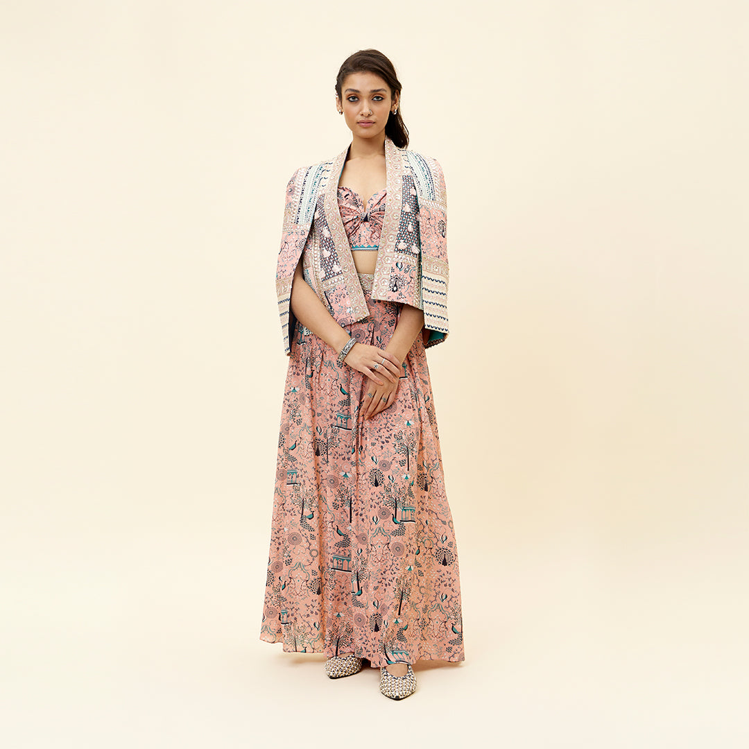 PINK MOR JAAL PRINT BIKINI BUSTIER TEAMED WITH BOX PLEATED PANTS AND A PATCHWORK NOOR CAPE JACKET