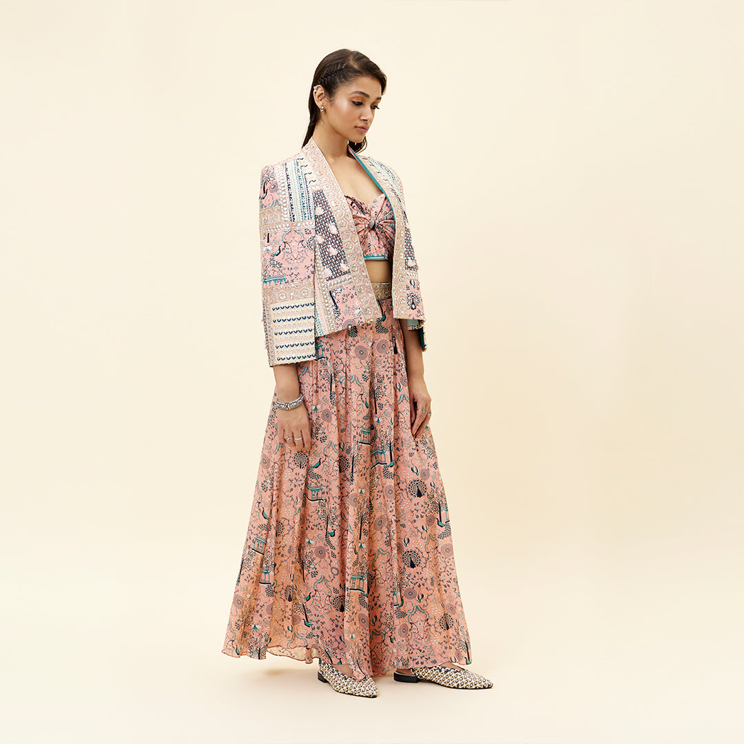 PINK MOR JAAL PRINT BIKINI BUSTIER TEAMED WITH BOX PLEATED PANTS AND A PATCHWORK NOOR CAPE JACKET