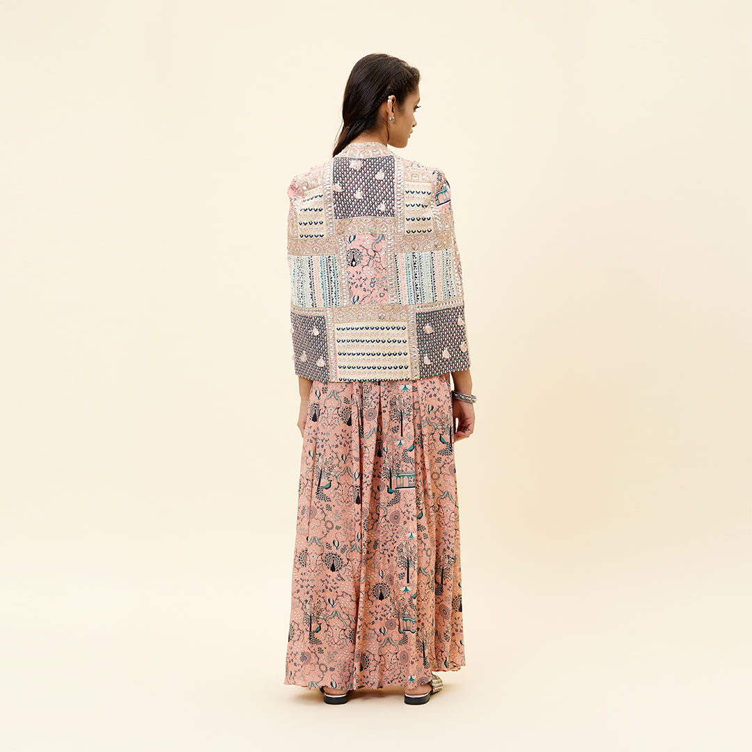 PINK MOR JAAL PRINT BIKINI BUSTIER TEAMED WITH BOX PLEATED PANTS AND A PATCHWORK NOOR CAPE JACKET