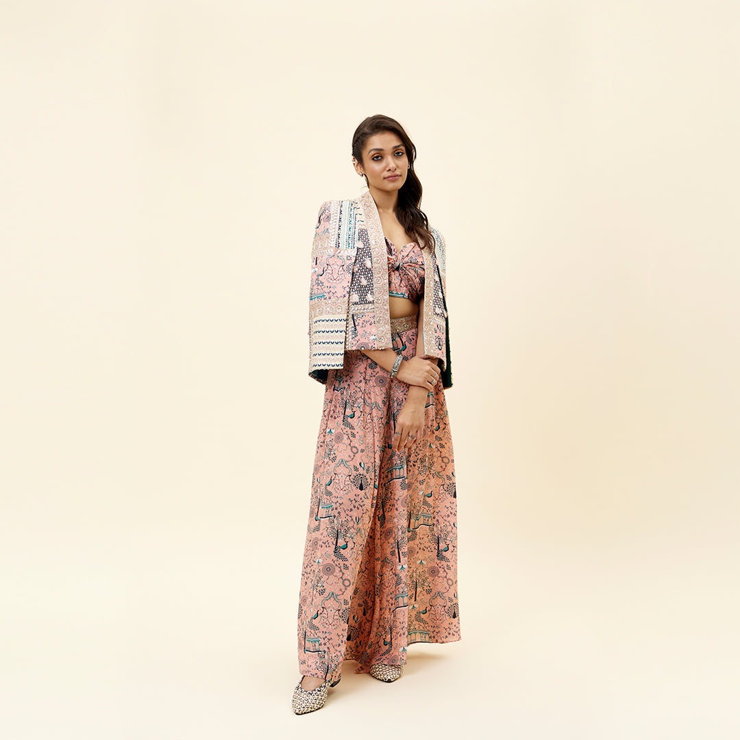 PINK MOR JAAL PRINT BIKINI BUSTIER TEAMED WITH BOX PLEATED PANTS AND A PATCHWORK NOOR CAPE JACKET