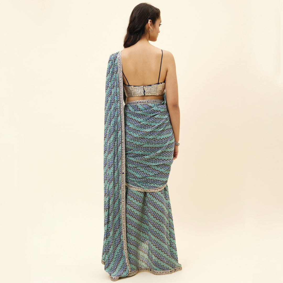 BEIGE LEAF PRINT PRE STITCHED CASCASE SAREE TEAMED WITH AN EMBELLISHED BLOUSE