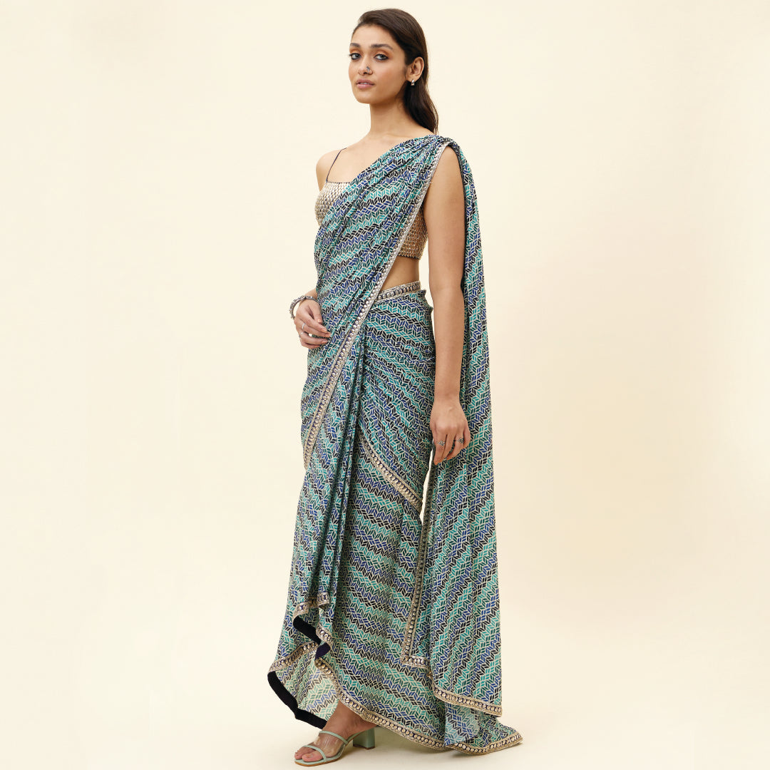 BEIGE LEAF PRINT PRE STITCHED CASCASE SAREE TEAMED WITH AN EMBELLISHED BLOUSE