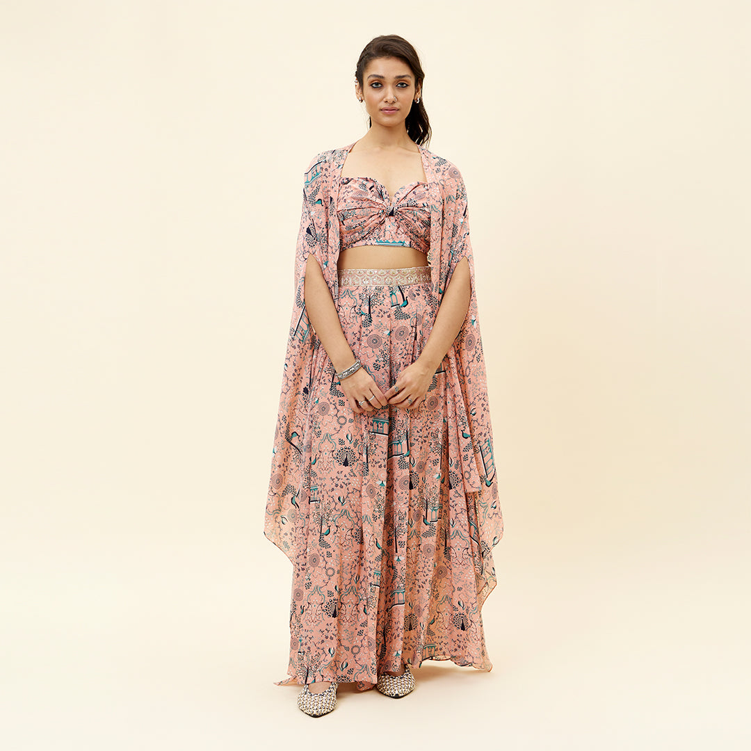 PINK MOR JAAL PRINT BIKINI BUSTIER TEAMED WITH BOX PLEATED PANTS AND A CAPE