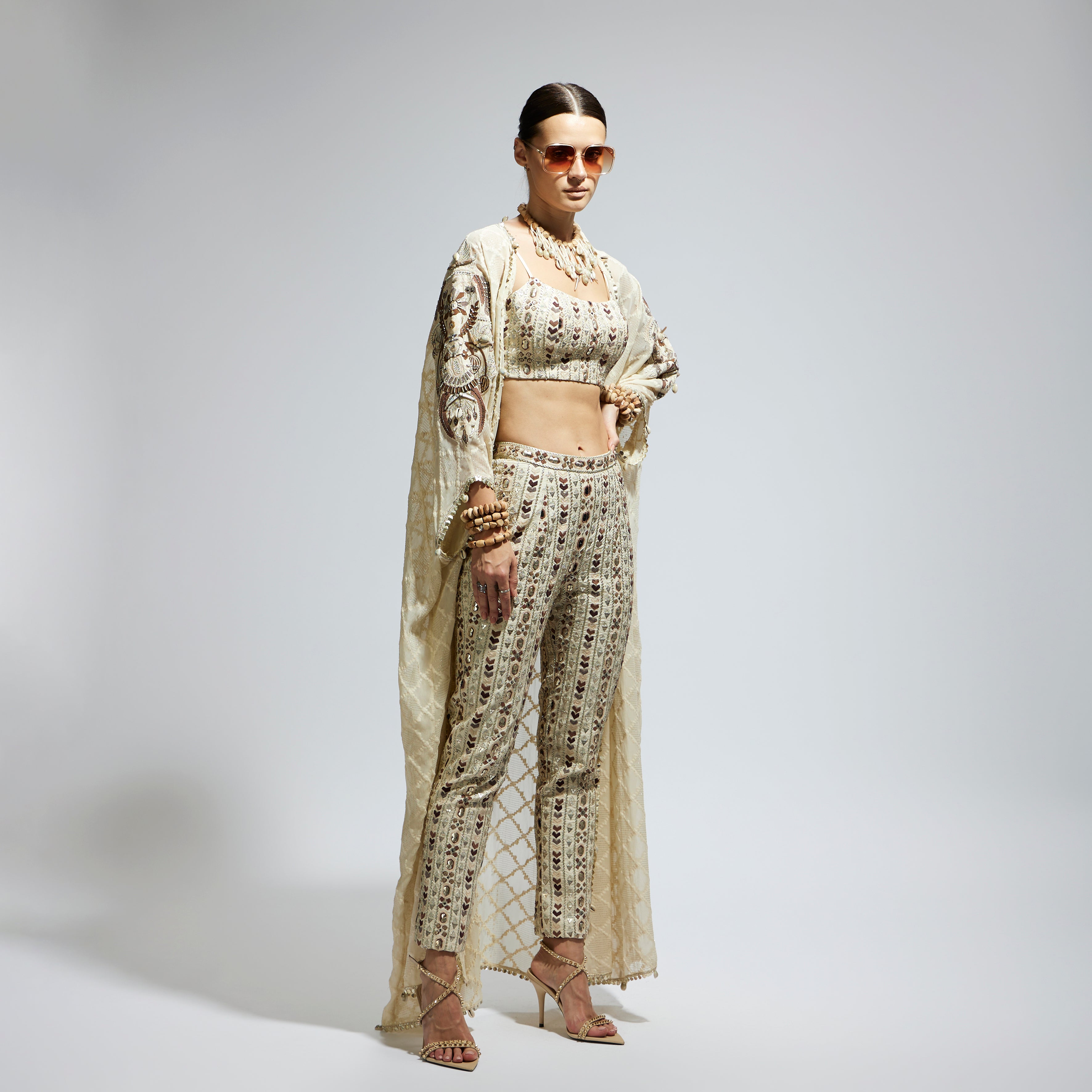 SAMSARA: IVORY AZTEC EMBELLISHED CAPE PAIRED WITH HEAVILY EMBELLISHED BUSTIER AND PANTS