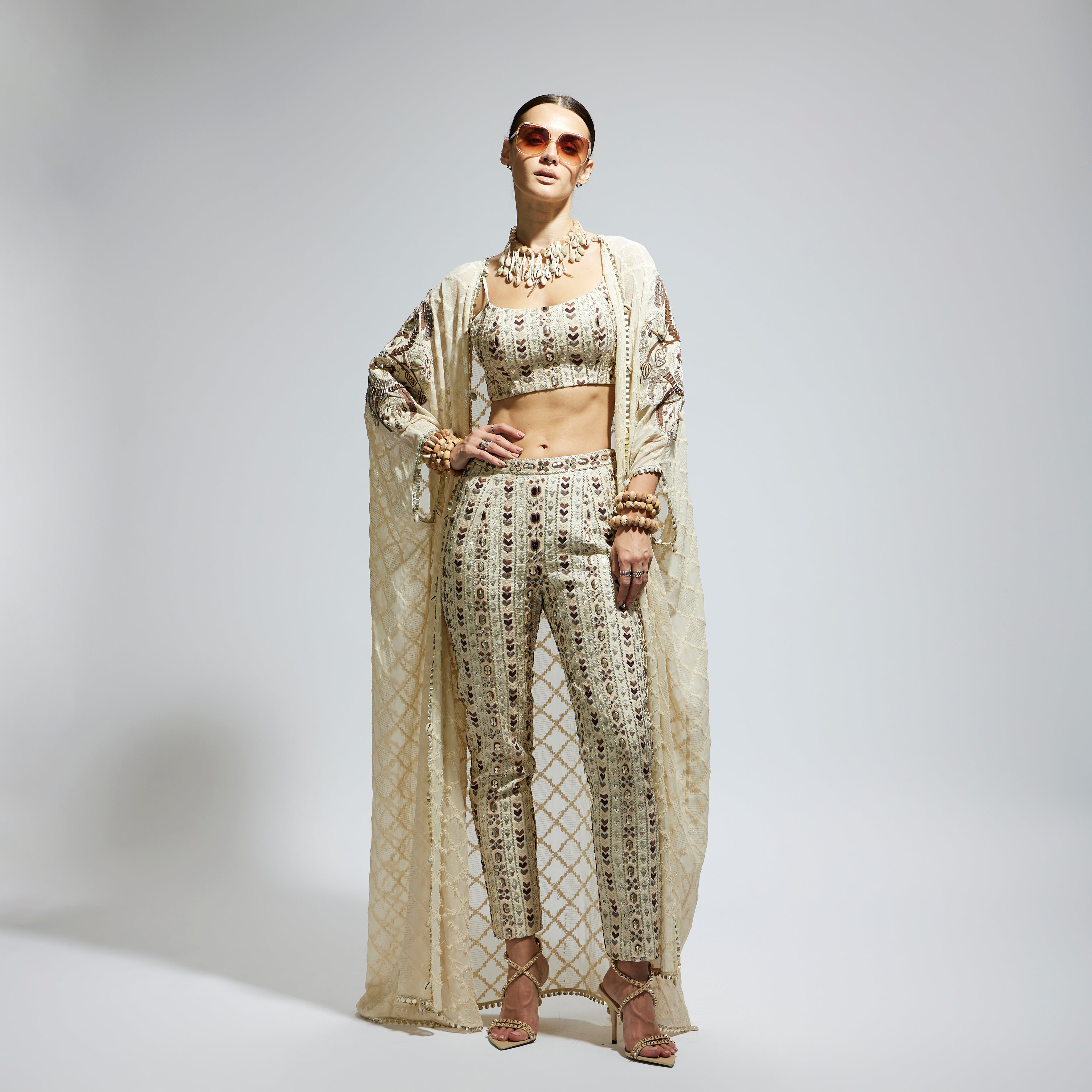 SAMSARA: IVORY AZTEC EMBELLISHED CAPE PAIRED WITH HEAVILY EMBELLISHED BUSTIER AND PANTS