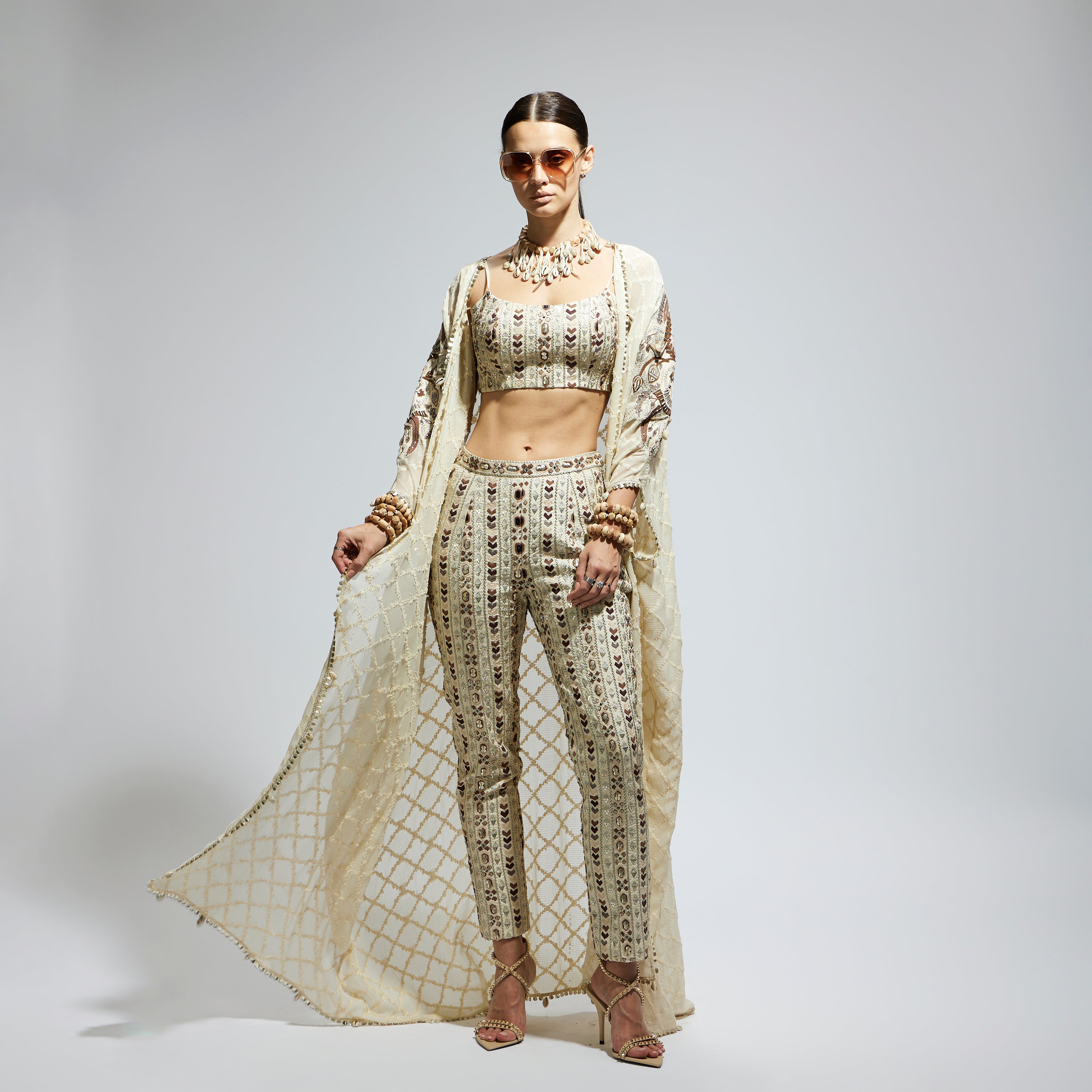 SAMSARA: IVORY AZTEC EMBELLISHED CAPE PAIRED WITH HEAVILY EMBELLISHED BUSTIER AND PANTS