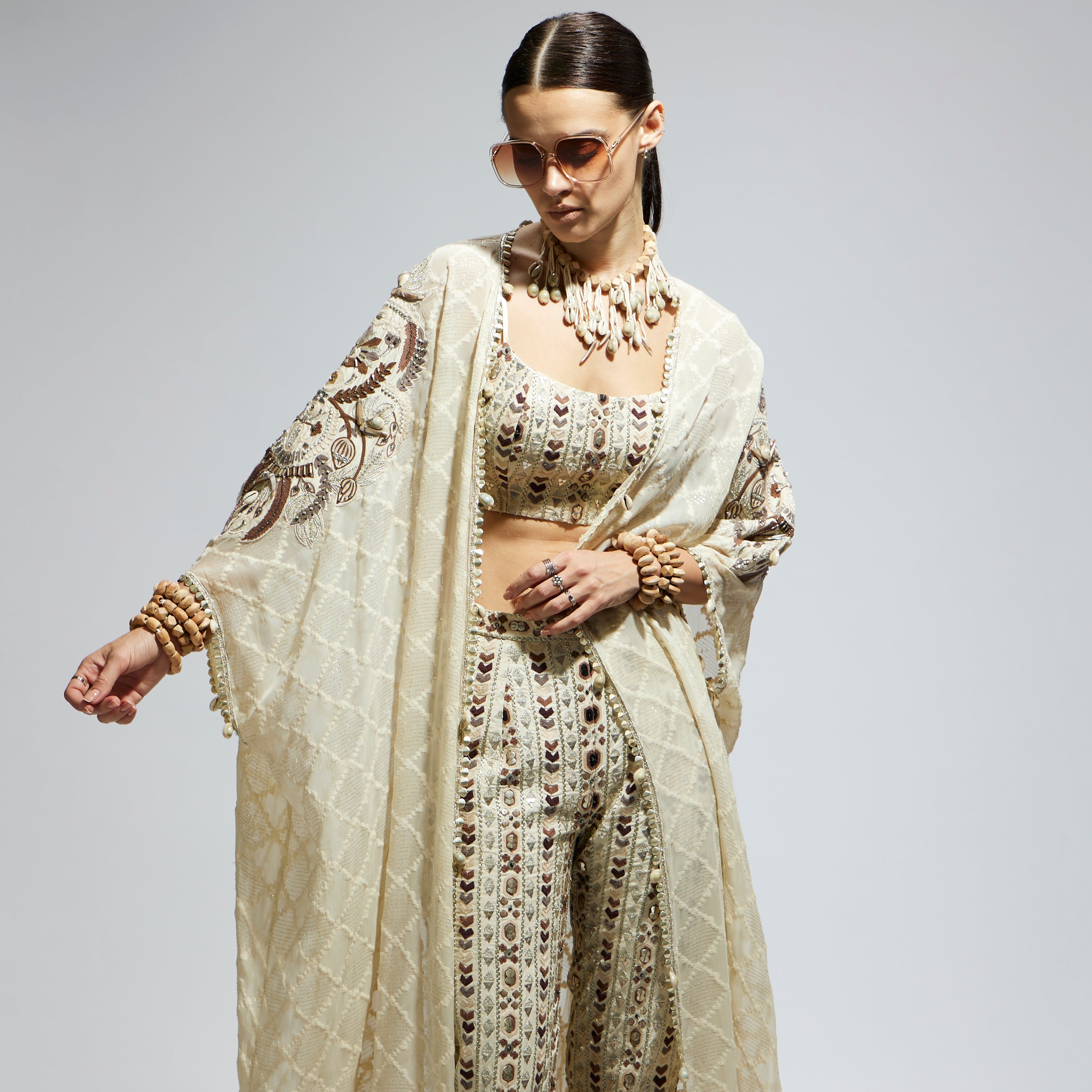 IVORY AZTEC EMBELLISHED CAPE PAIRED WITH HEAVILY EMBELLISHED BUSTIER AND PANTS