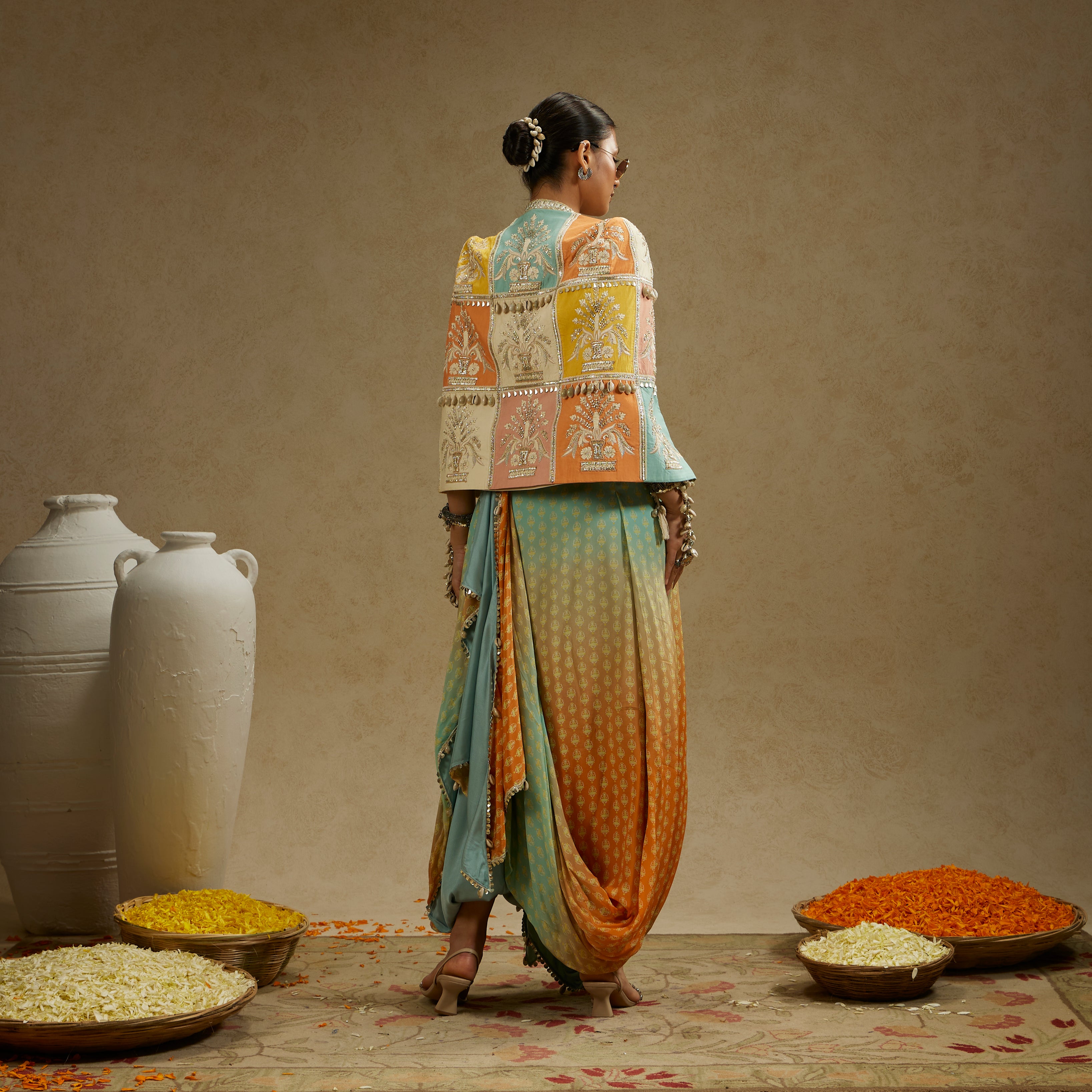 COLOUR BLOCKED PATCHWORK CAPE JACKET PAIRED WITH AN EMBELLISHED BUSTIER AND AN OMBRE PRINTED DRAPED SKIRT