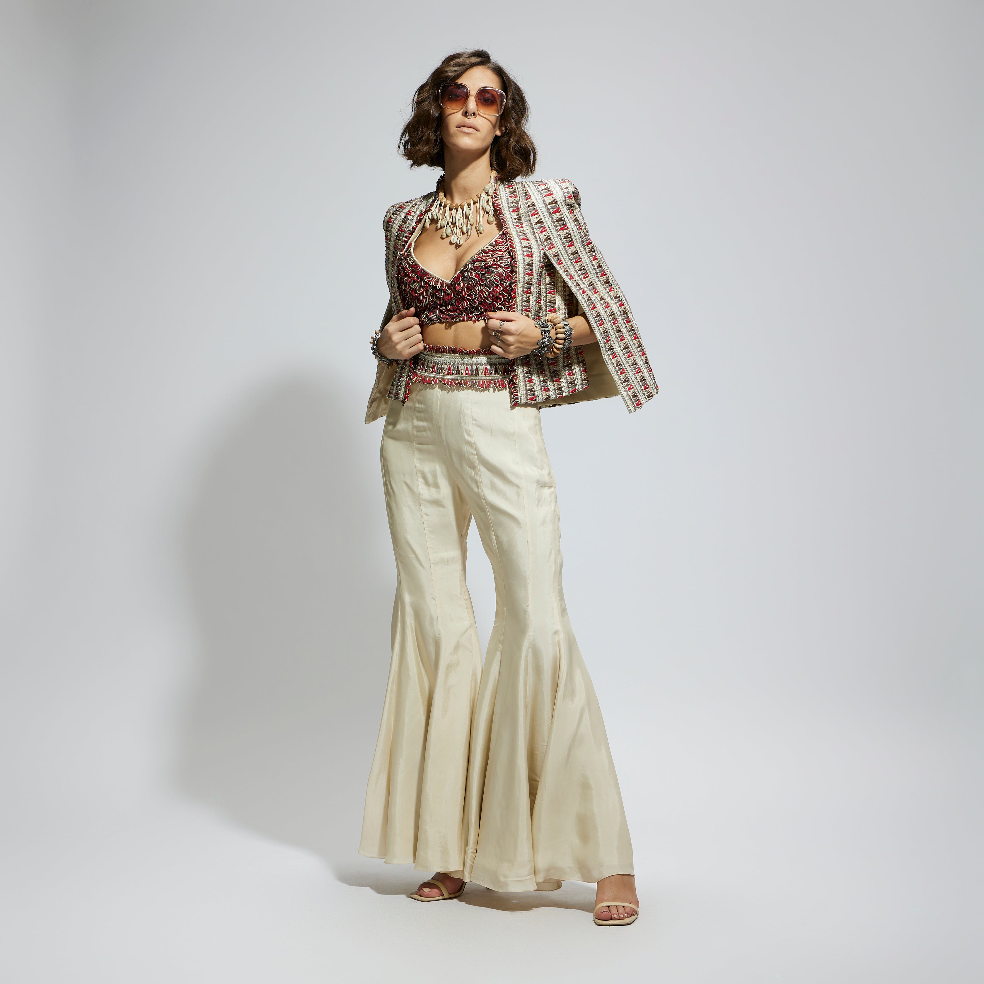 SAMSARA: IVORY EMBELLISHED CAPE JACKET PAIRED WITH TEXTURED BUSTIER AND SHARARA PANTS