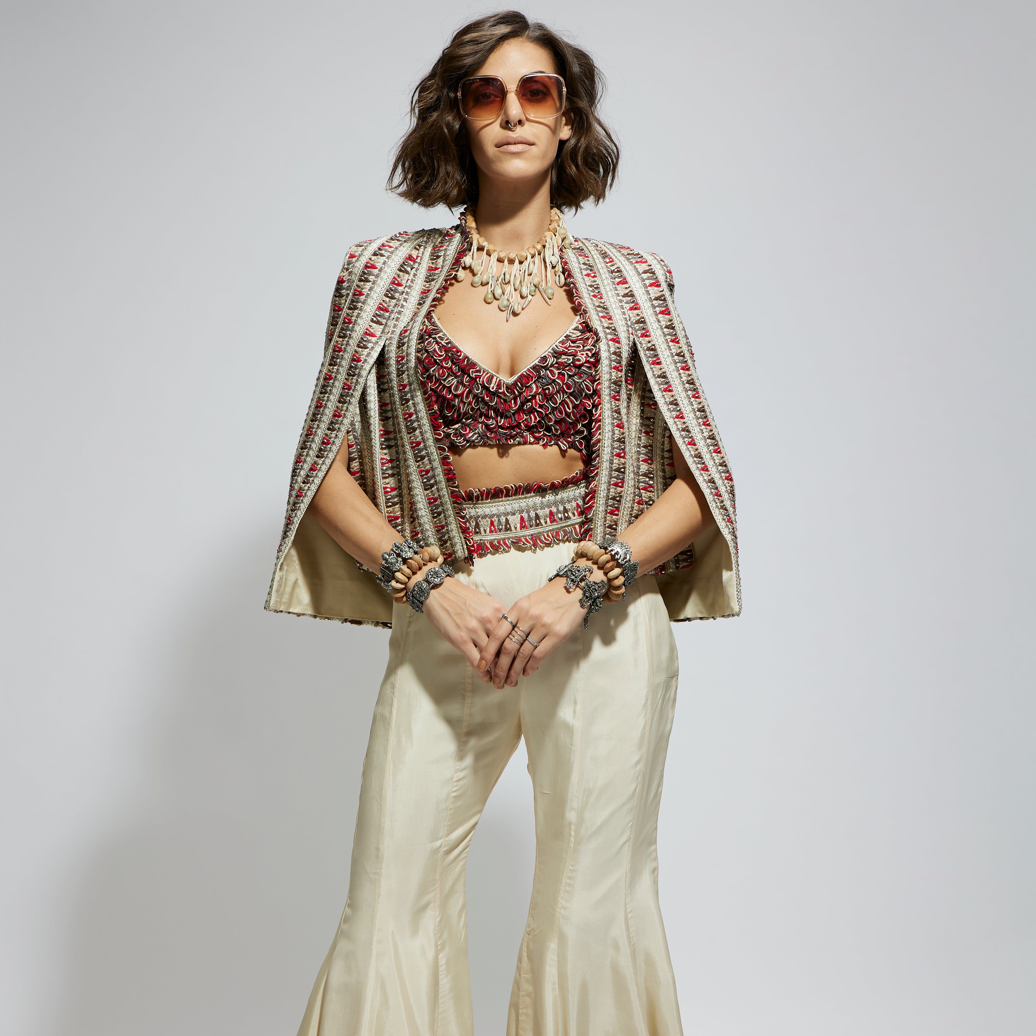 IVORY EMBELLISHED CAPE JACKET PAIRED WITH TEXTURED BUSTIER AND SHARARA PANTS
