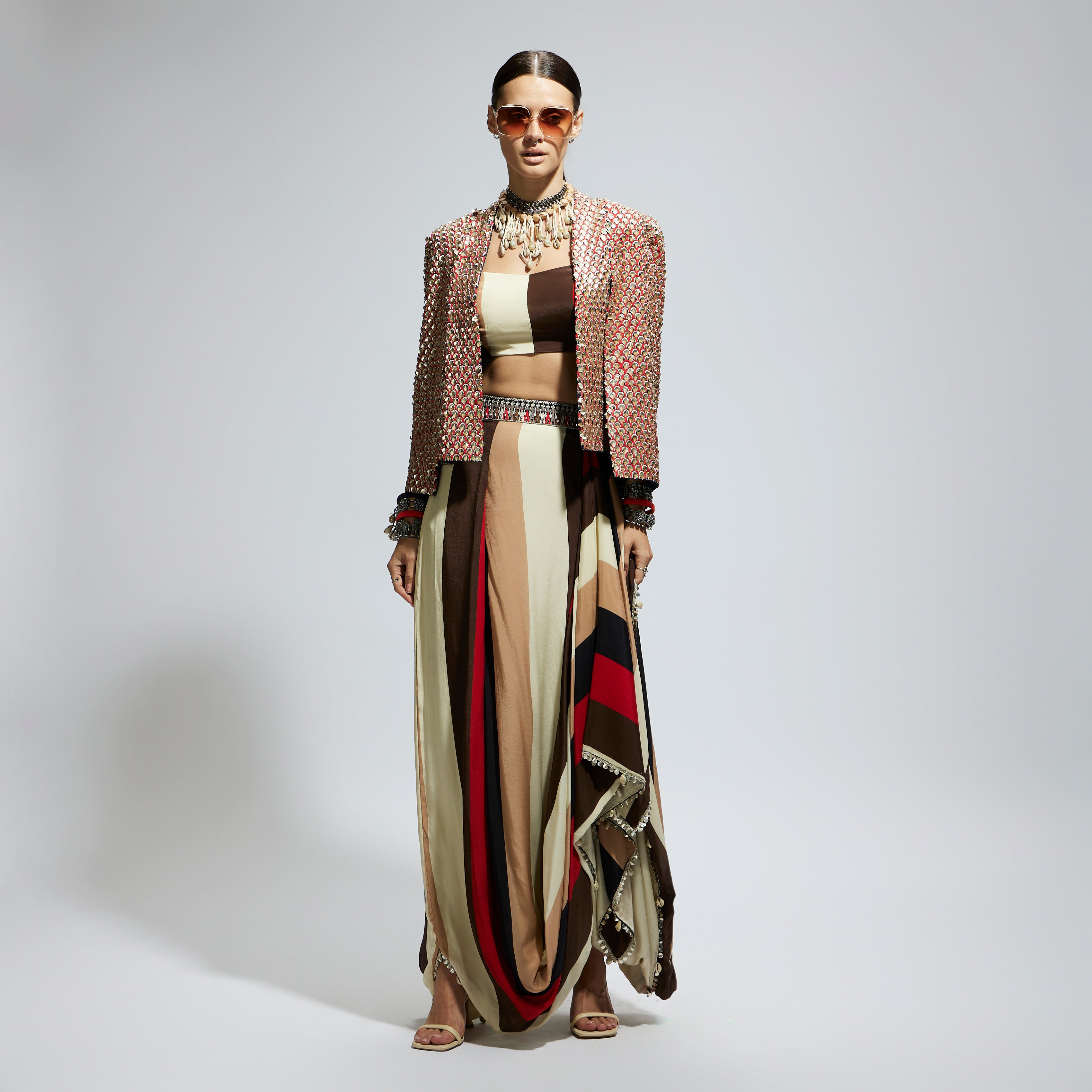 METALLIC EMBELLISHED CAPE JACKET PAIRED WITH STRIPE BUSTIER AND STRIPE DRAPE SKIRT