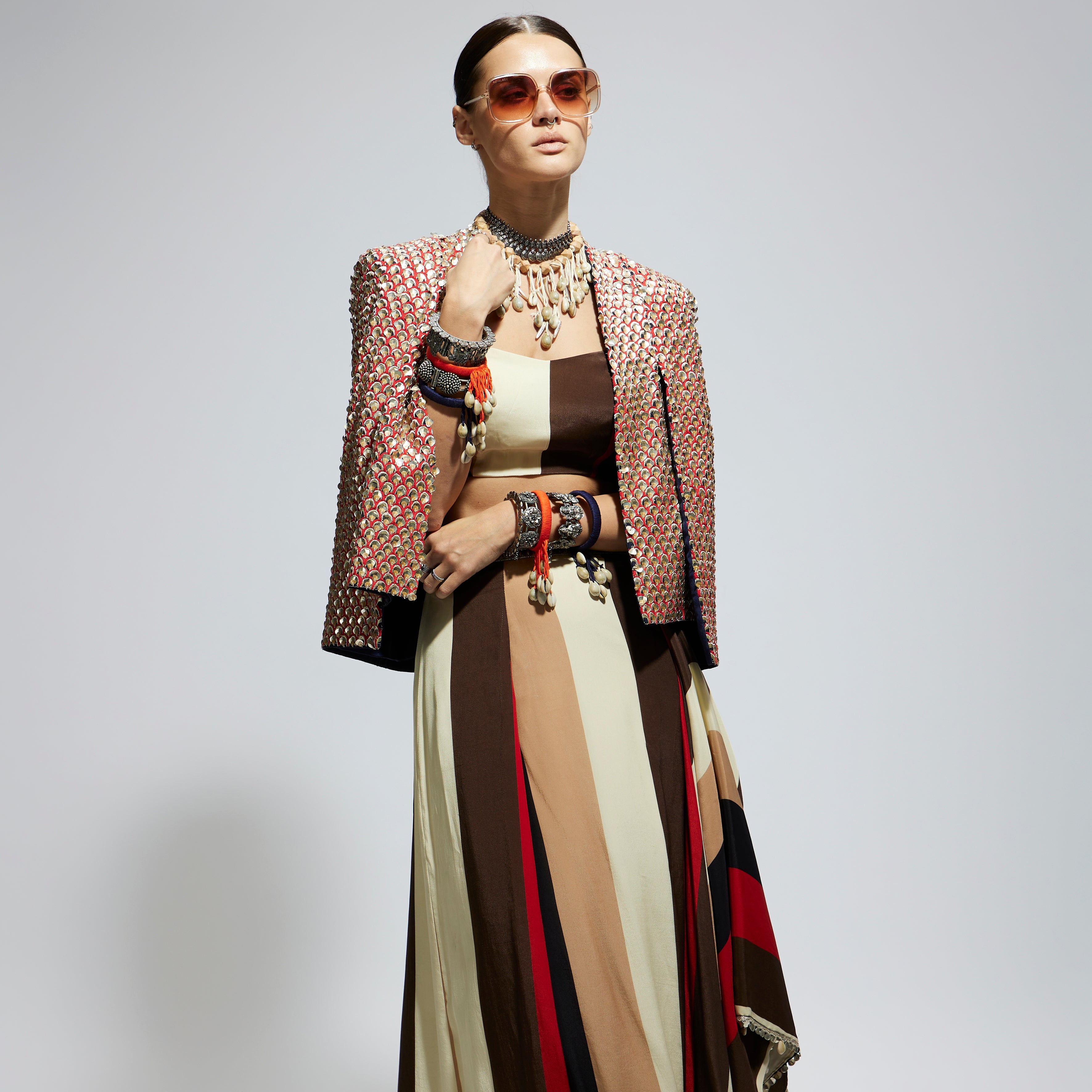 METALLIC EMBELLISHED CAPE JACKET PAIRED WITH STRIPE BUSTIER AND STRIPE DRAPE SKIRT