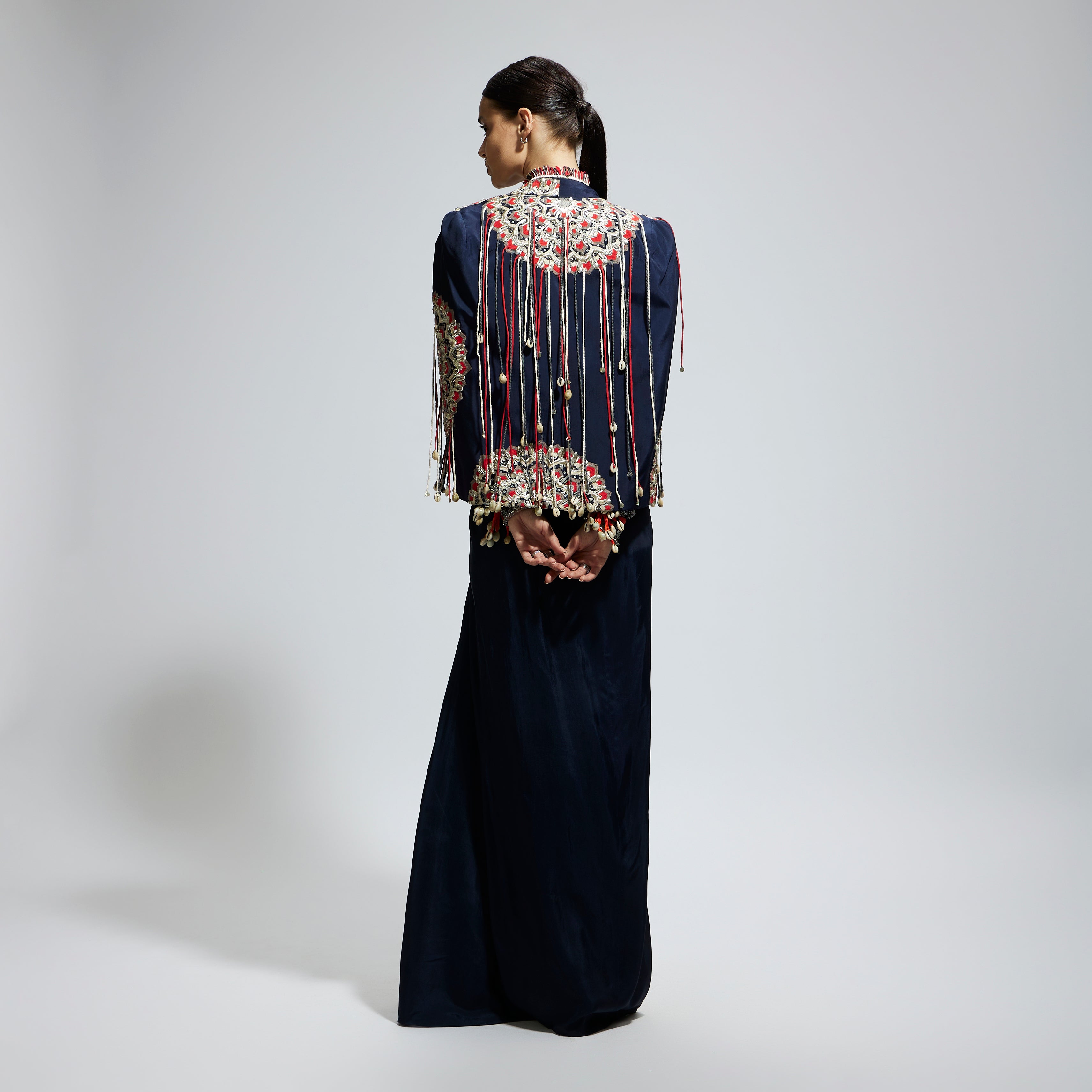 SAMSARA: BLUE ASYMETRIC THREADWORK CAPE JACKET PAIRED WITH AN EMBELLISHED BUSTIER AND HIGH SLIT SKIRT