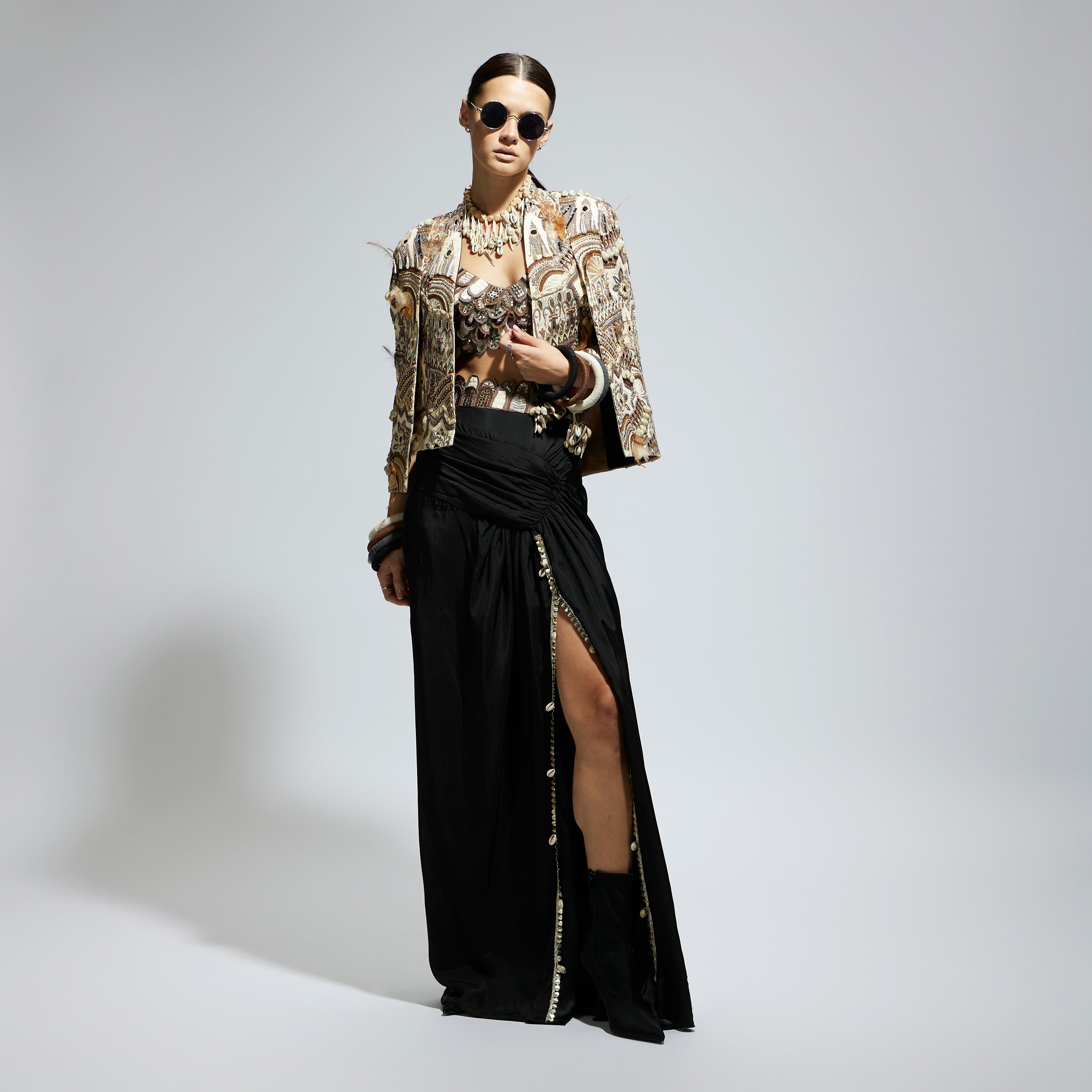 IVORY ABSTRACT FEATHER CAPE JACKET PAIRED WITH 3D SCALLOP BUSTIER AND BLACK HIGH SLIT SKIRT