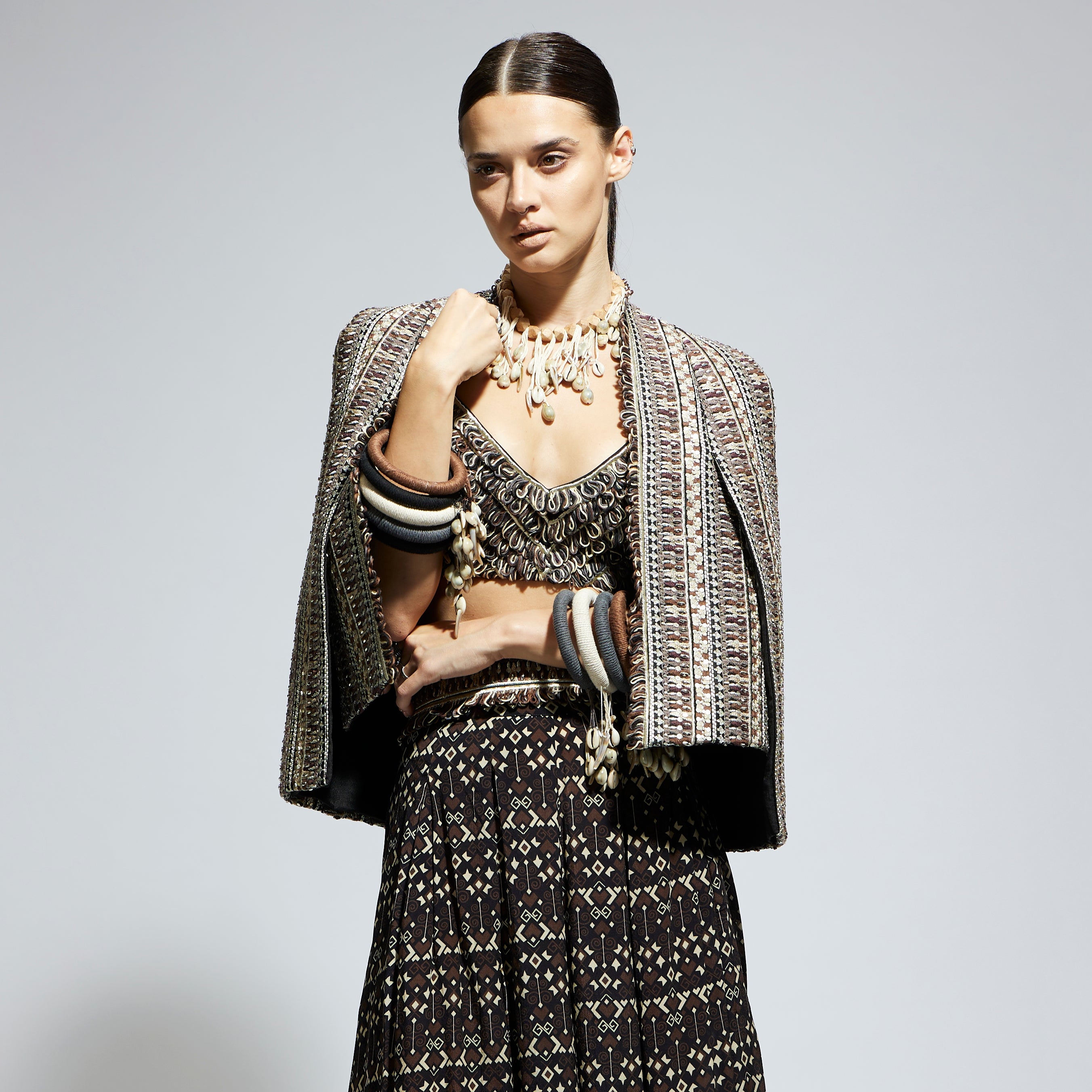 BROWN THREADWORK CAPE JACKET PAIRED WITH TEXTURED BUSTIER AND FLARED PANTS