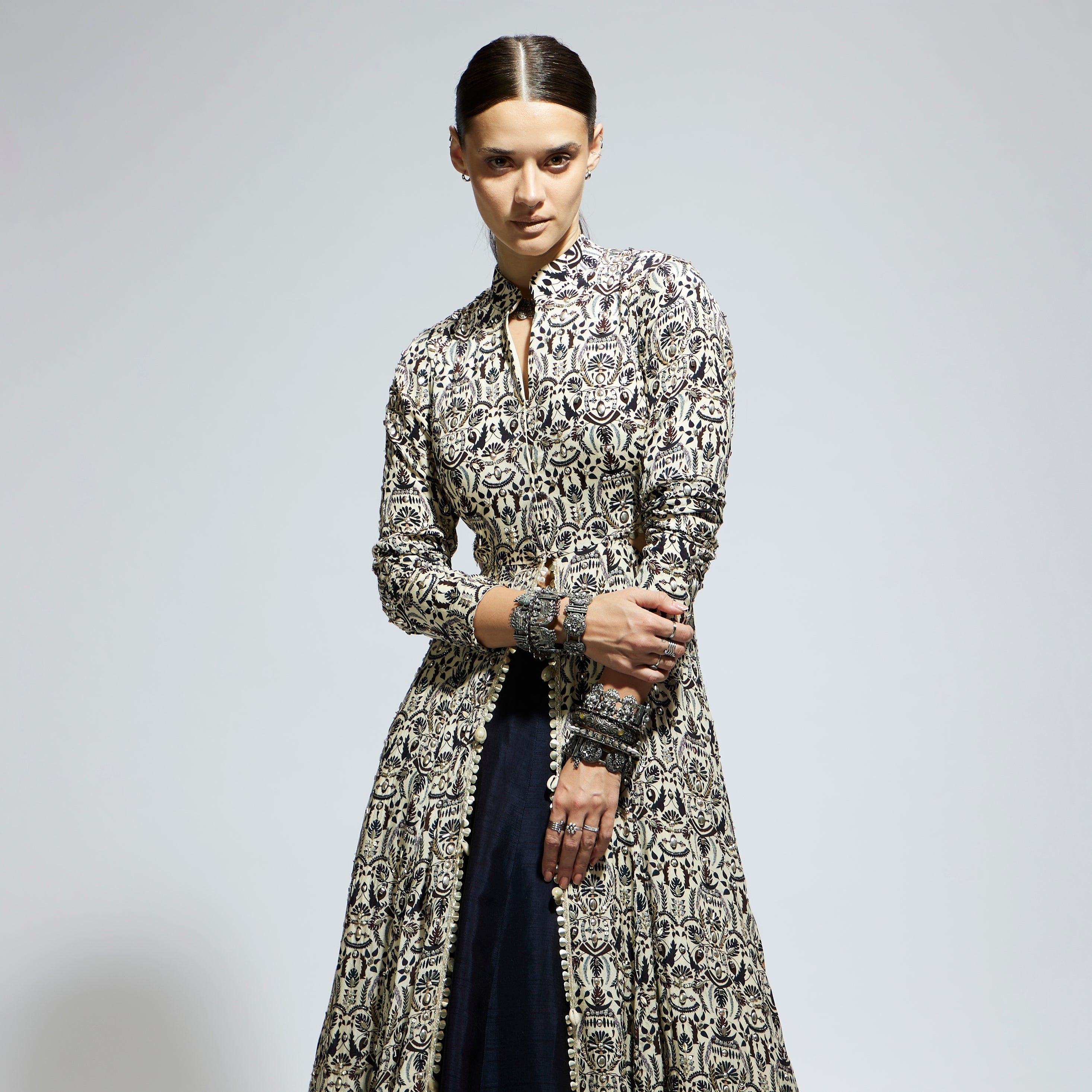 SAMSARA: WHITE HEAVILY EMBELLISHED WAIST CUT OUT JACKET PAIRED WITH A MIDNIGHT BLUE LEHENGA