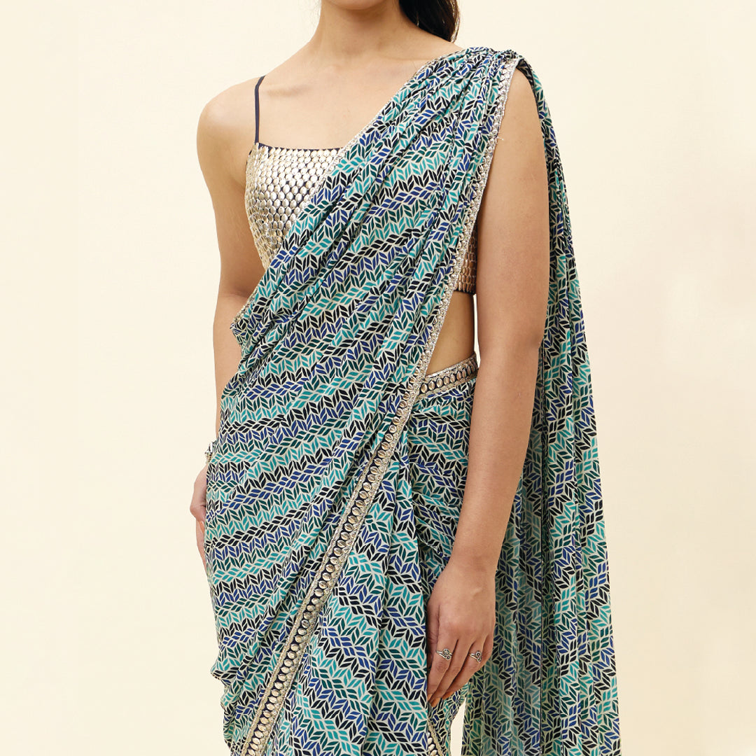 BEIGE LEAF PRINT PRE STITCHED CASCASE SAREE TEAMED WITH AN EMBELLISHED BLOUSE