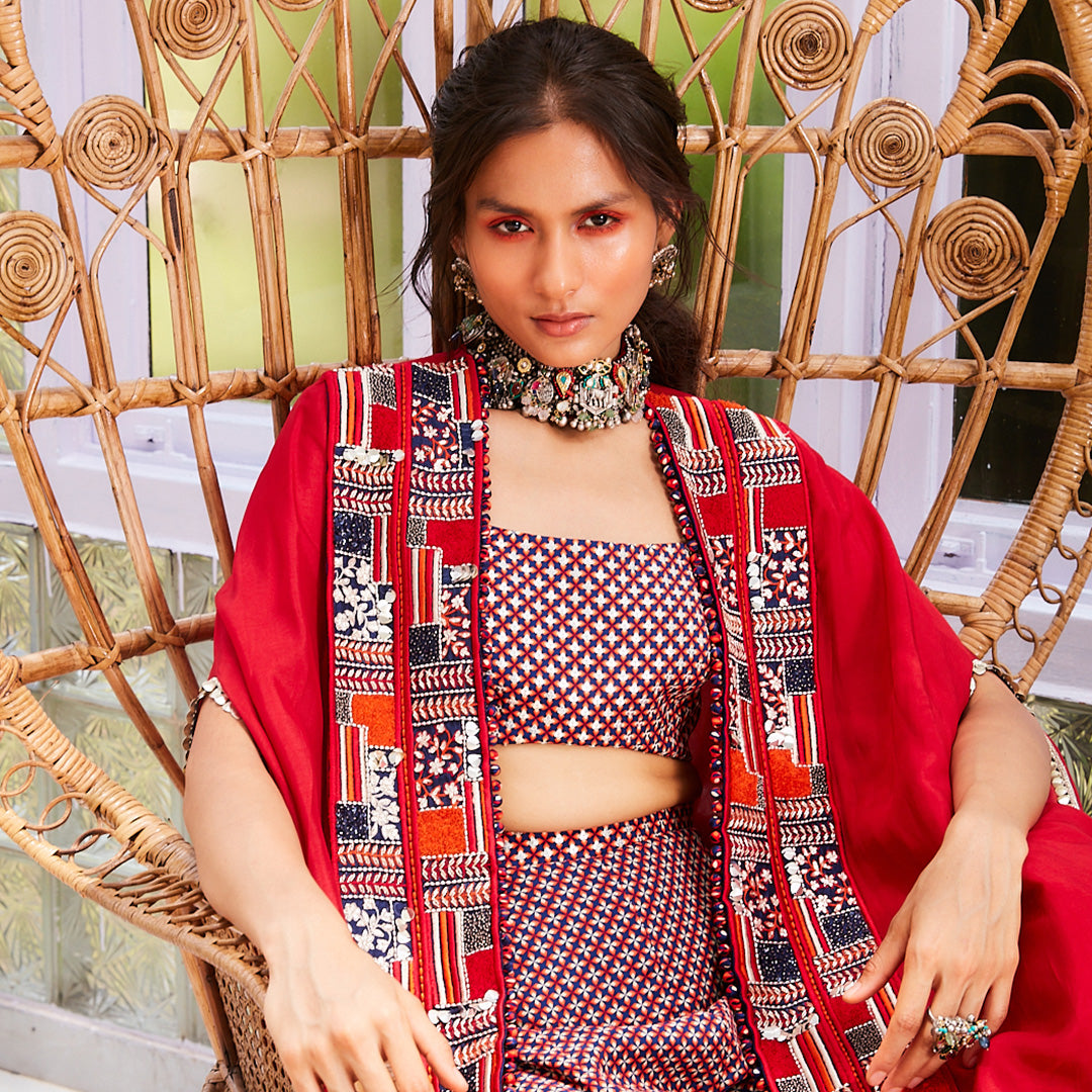 BLUE GEO RASA PRINT SHARARA WITH BLUE GEO PRINT RASA BUSTIER AND SOLID RED CAPE WITH PATCHWORK PRINT BORDER